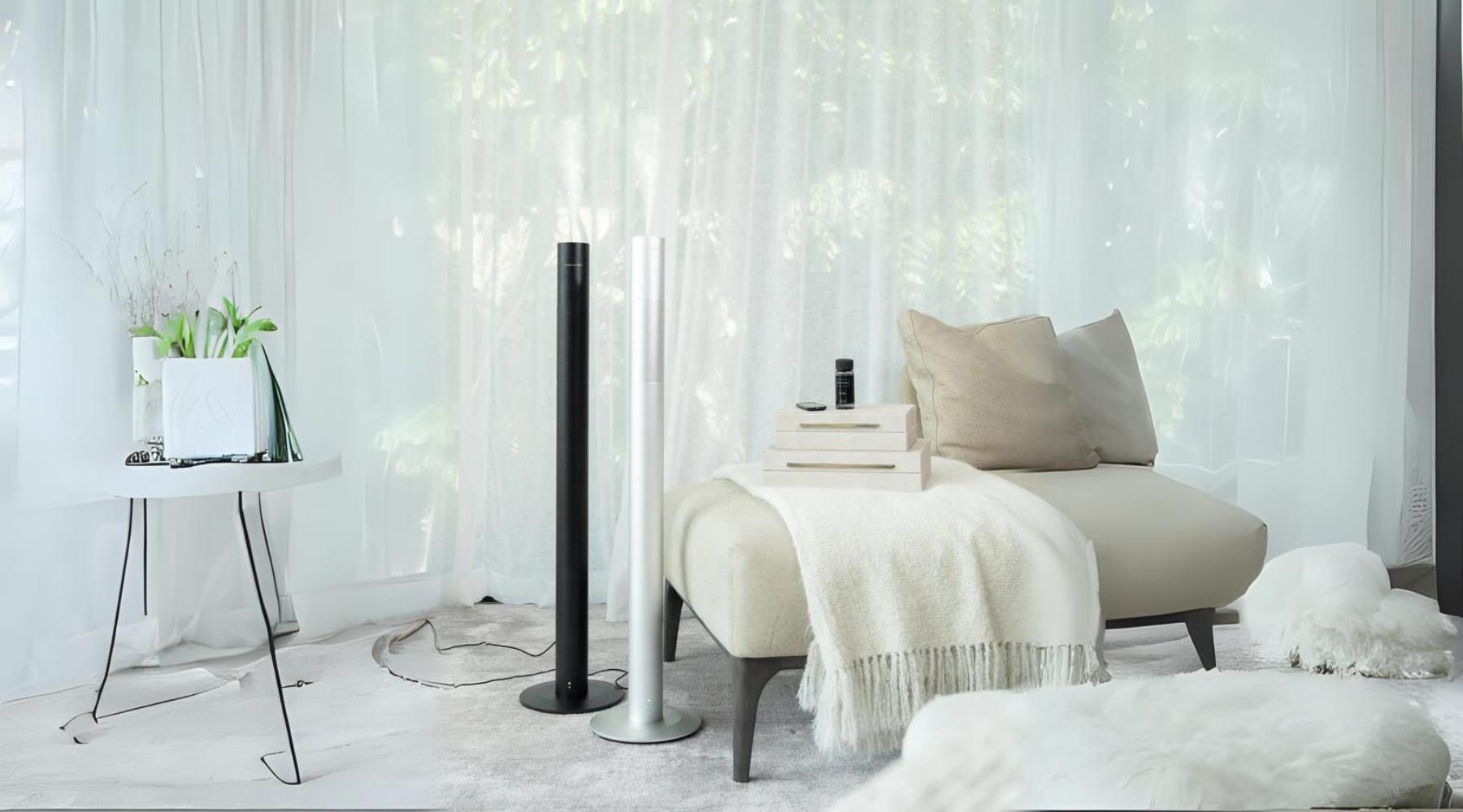 A lifestyle image of two of Aroma360's Michelangelo360 Scent Diffusers in Midnight Black and Metallic Silver next to Aroma360's Pro-Pod Fragrance Oil