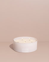 Luxurious 6-wick Déjà Vu candle set inspired by Vogue Brazil, featuring notes of bergamot, rose, and honeyed orchid. Includes a 50oz candle, wick trimmer, and matchbox for an unforgettable sensory experience.